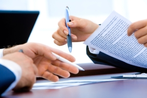 Business hands with pens and documents.